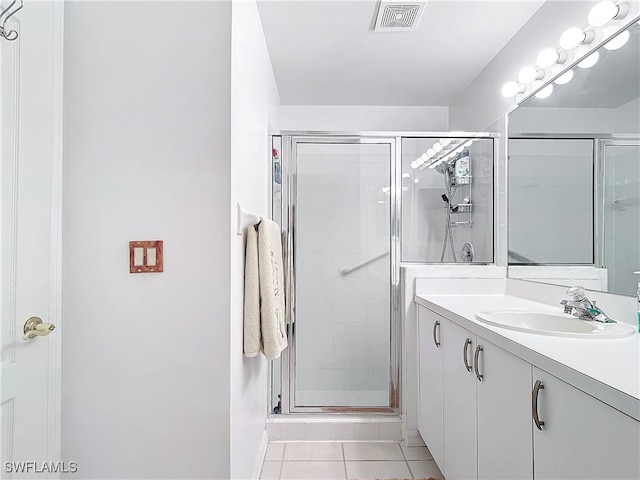 bathroom with vanity, a shower with shower door, and tile patterned flooring