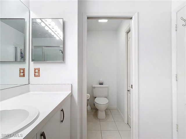 bathroom featuring vanity, tile patterned floors, toilet, and an enclosed shower