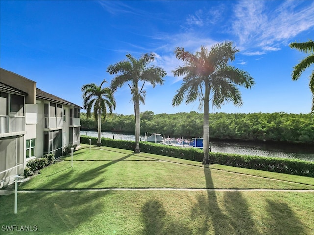 view of sport court featuring a yard and a water view