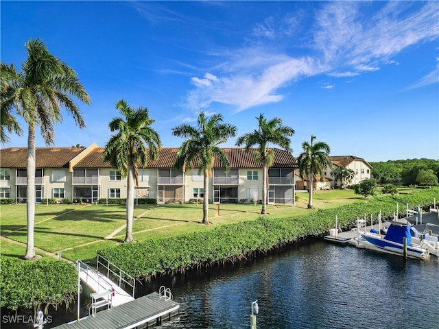 dock area with a yard, a water view, and a balcony