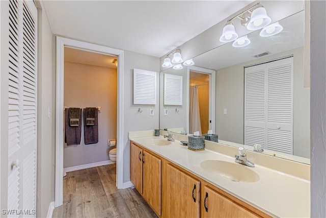 bathroom with vanity, toilet, and hardwood / wood-style floors