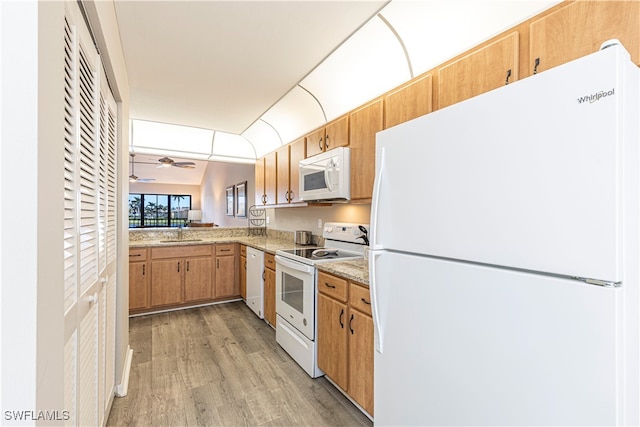 kitchen with white appliances, sink, vaulted ceiling, light hardwood / wood-style floors, and ceiling fan