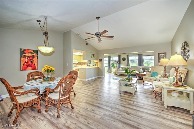 dining area with ceiling fan, lofted ceiling, and light hardwood / wood-style flooring