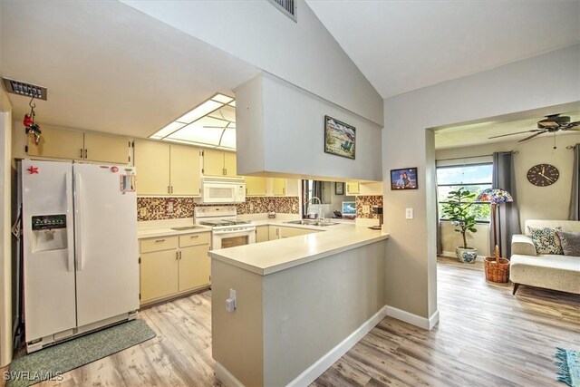 kitchen featuring cream cabinetry, light hardwood / wood-style floors, white appliances, and sink