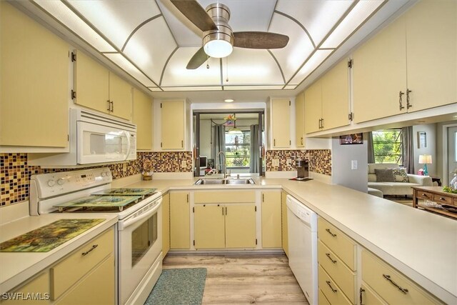 kitchen featuring white appliances, sink, and cream cabinets