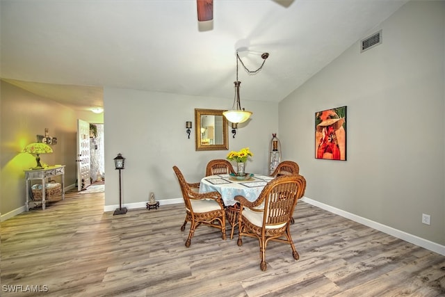 dining area with light hardwood / wood-style floors and vaulted ceiling