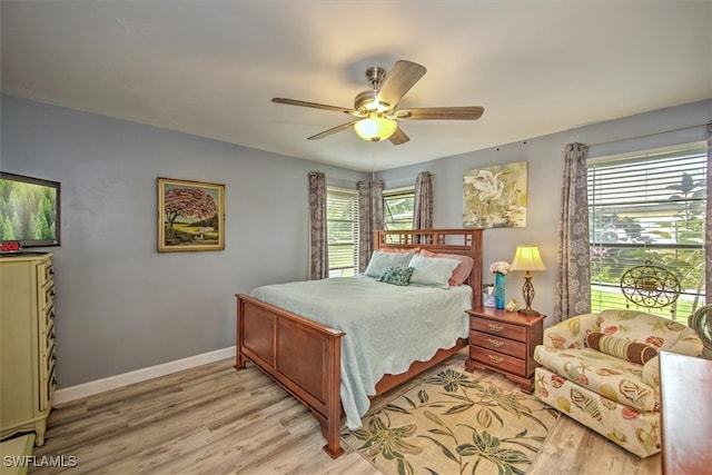 bedroom with light hardwood / wood-style floors, multiple windows, and ceiling fan