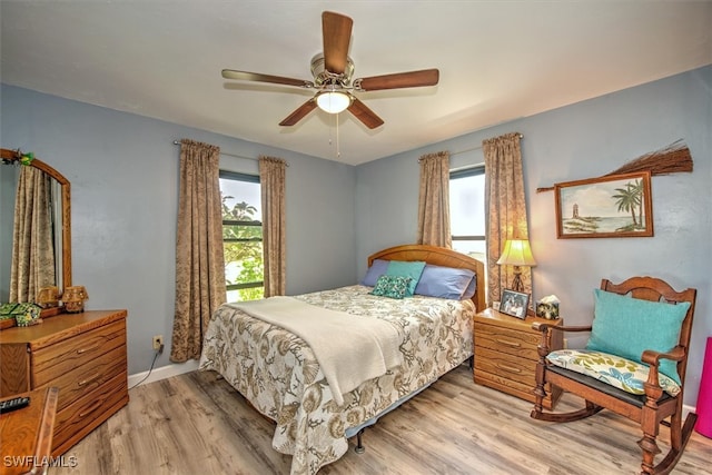 bedroom featuring multiple windows, ceiling fan, and light wood-type flooring