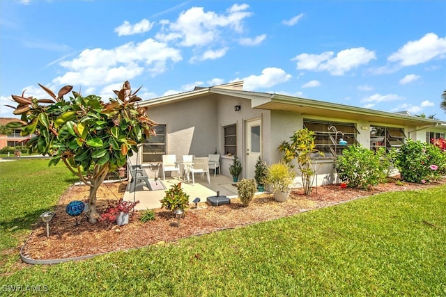 back of property featuring a yard and a patio