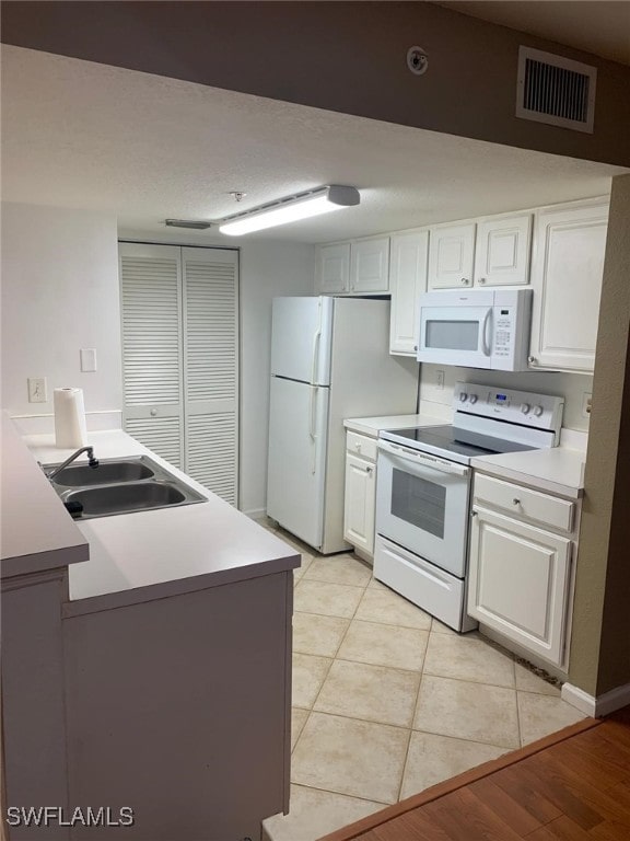 kitchen featuring white cabinetry, sink, and white appliances