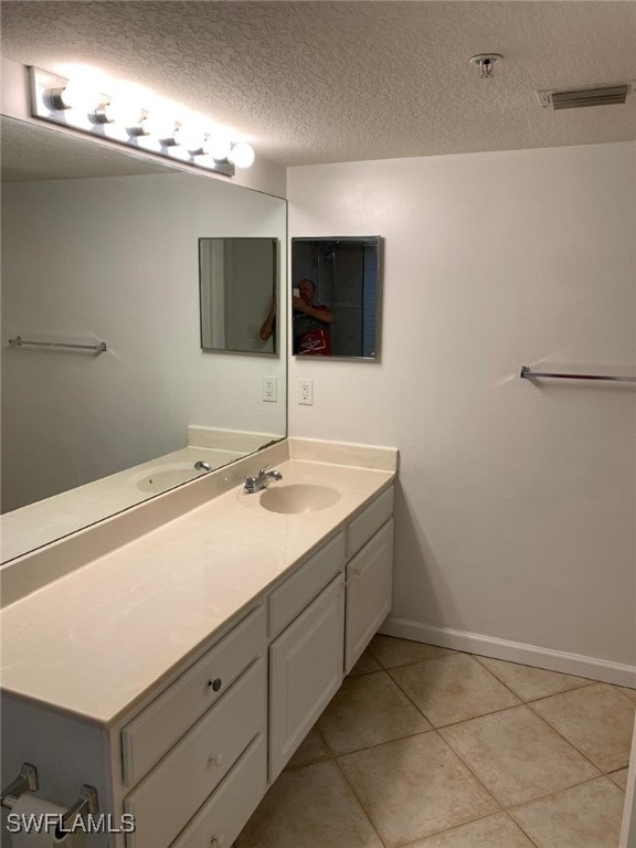 bathroom featuring vanity, a textured ceiling, and tile patterned flooring