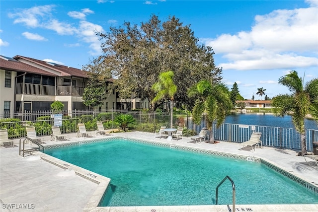 view of swimming pool with a water view and a patio