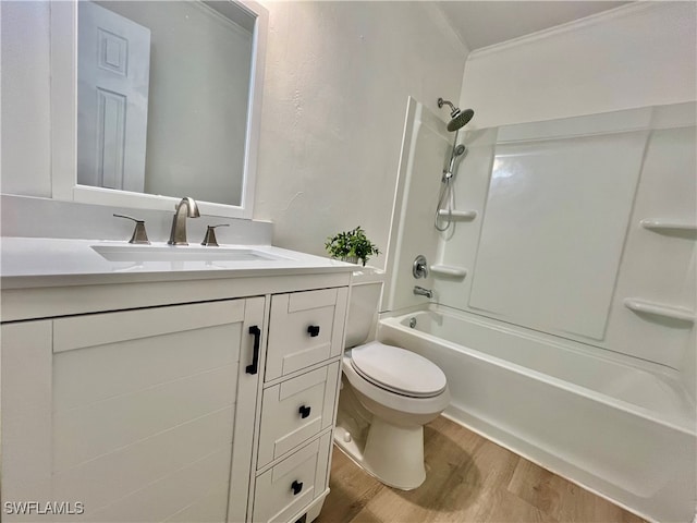 full bathroom featuring washtub / shower combination, toilet, ornamental molding, vanity, and hardwood / wood-style flooring