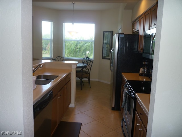 kitchen featuring light tile patterned flooring, appliances with stainless steel finishes, sink, and hanging light fixtures