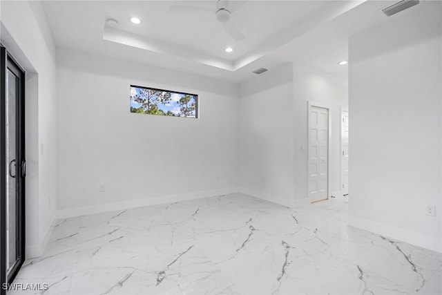 unfurnished room with a tray ceiling and ceiling fan