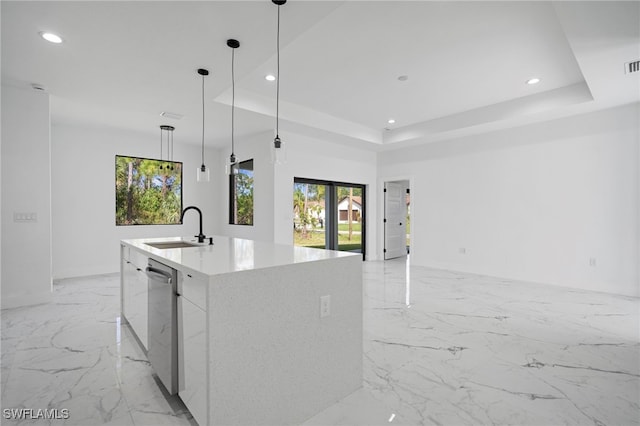 kitchen featuring dishwasher, an island with sink, a tray ceiling, sink, and pendant lighting