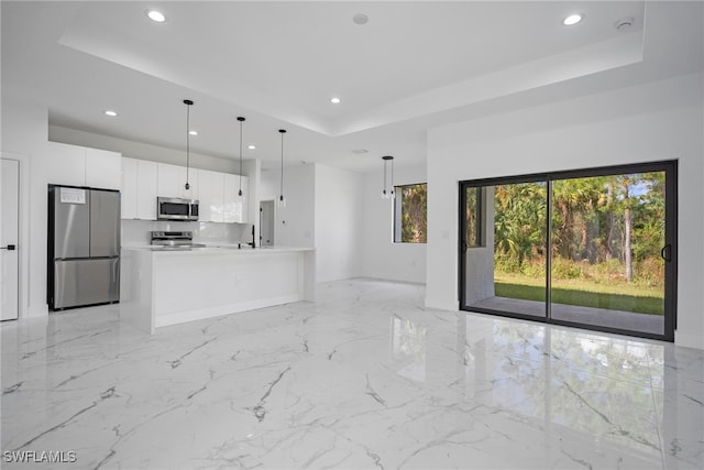 unfurnished living room featuring sink and a tray ceiling