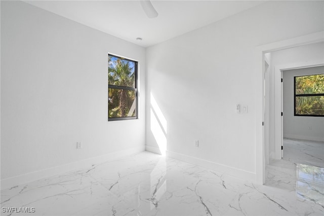 spare room with a healthy amount of sunlight and ceiling fan