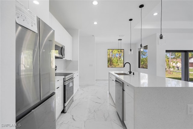 kitchen featuring a spacious island, stainless steel appliances, sink, pendant lighting, and white cabinets