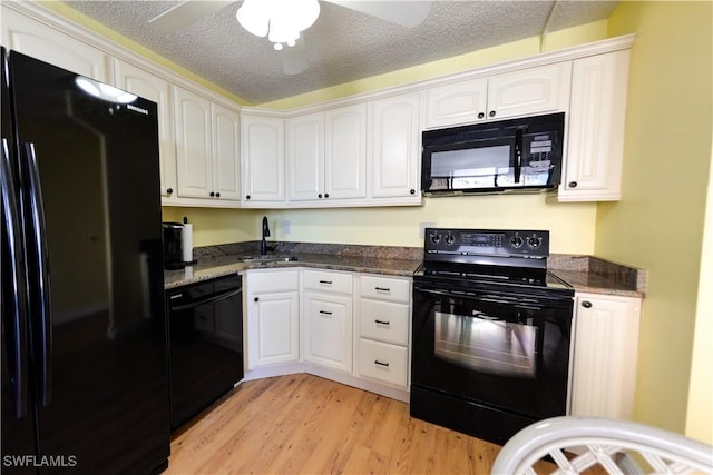 kitchen featuring black appliances, white cabinets, sink, light hardwood / wood-style flooring, and a textured ceiling