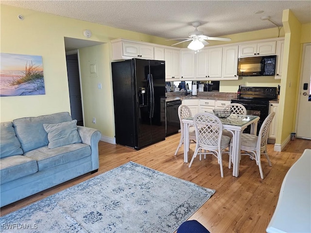 kitchen featuring ceiling fan, light hardwood / wood-style floors, a textured ceiling, white cabinets, and black appliances