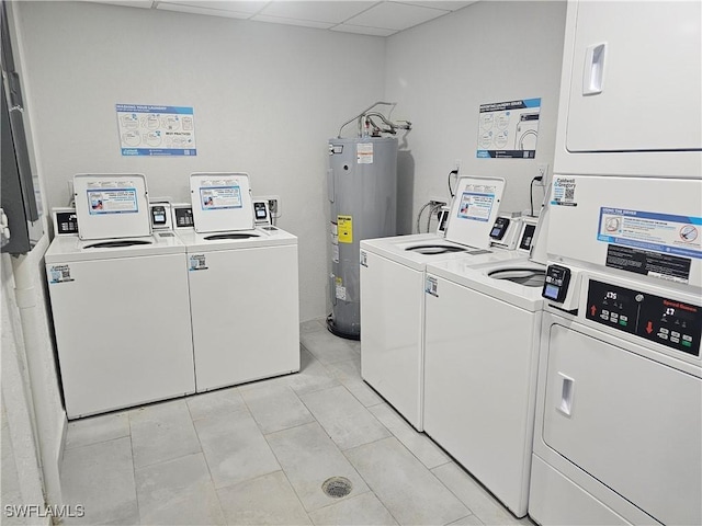 clothes washing area featuring light tile patterned floors, separate washer and dryer, stacked washer and clothes dryer, and water heater