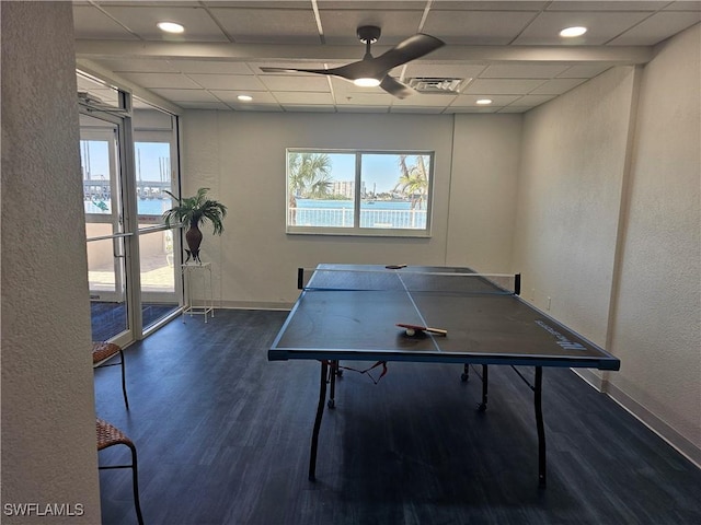 recreation room featuring a paneled ceiling, ceiling fan, a water view, and dark wood-type flooring