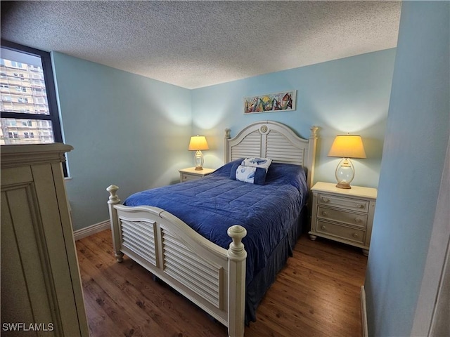 bedroom featuring dark hardwood / wood-style flooring and a textured ceiling