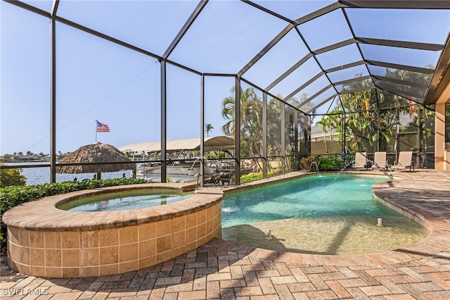 view of swimming pool with a patio, a lanai, an in ground hot tub, and pool water feature