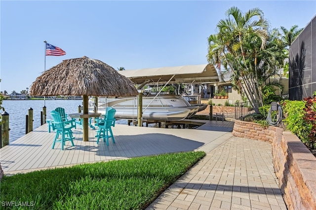 view of dock with a lanai and a water view