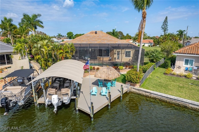 dock area with a patio, a yard, a water view, and glass enclosure