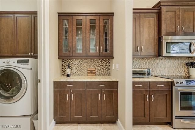 laundry area with washer / dryer, cabinets, and light tile patterned floors