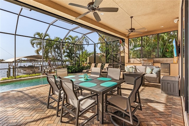 view of patio featuring exterior kitchen, ceiling fan, and a lanai