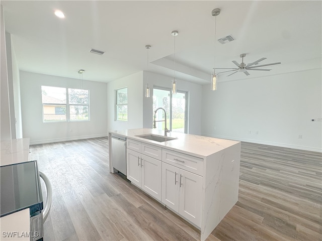 kitchen featuring white cabinets, a healthy amount of sunlight, sink, and decorative light fixtures