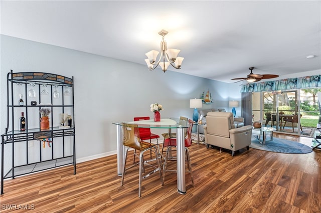 dining area featuring hardwood / wood-style floors and ceiling fan with notable chandelier