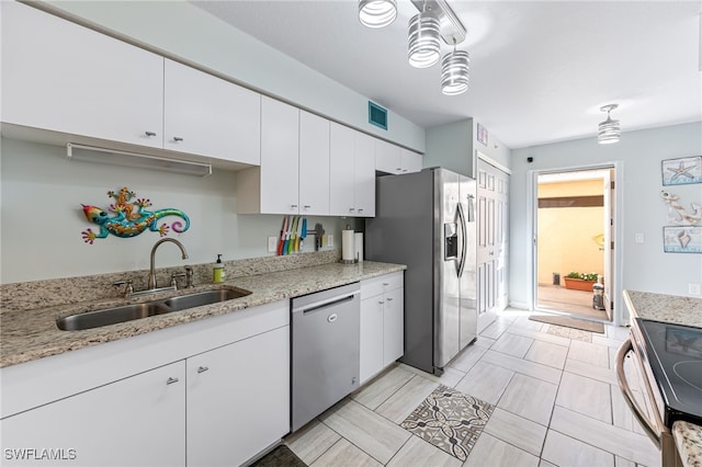 kitchen featuring stainless steel appliances, white cabinetry, sink, and light stone counters