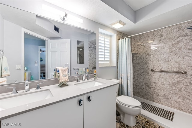 bathroom featuring curtained shower, vanity, and toilet