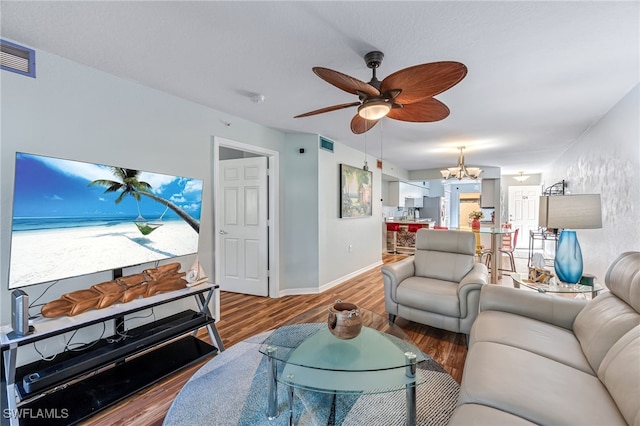 living room with wood-type flooring and ceiling fan with notable chandelier