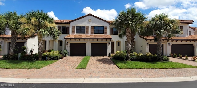 mediterranean / spanish-style home featuring a front lawn and a garage