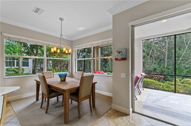 tiled dining space with a notable chandelier, crown molding, and a healthy amount of sunlight