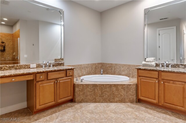 bathroom with vanity, tiled bath, and tile patterned flooring