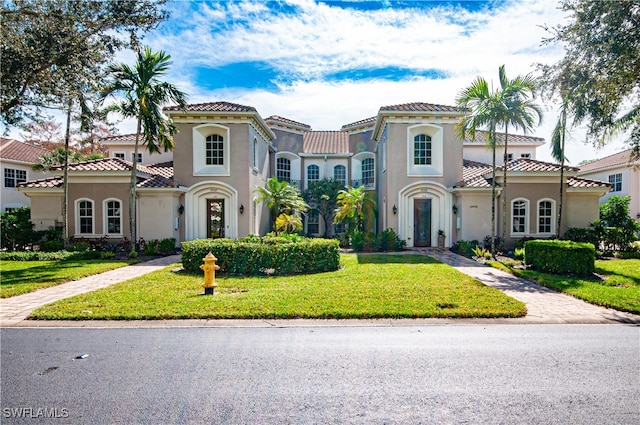 mediterranean / spanish house with a front lawn