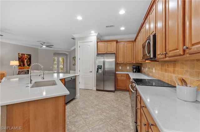 kitchen featuring ornamental molding, appliances with stainless steel finishes, sink, and a kitchen island with sink