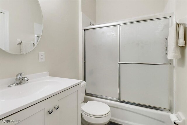 full bathroom featuring vanity, toilet, and combined bath / shower with glass door