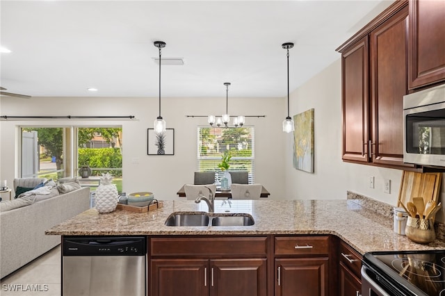 kitchen featuring light stone countertops, a notable chandelier, sink, and stainless steel appliances