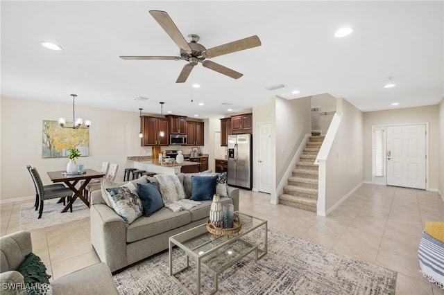 tiled living room featuring ceiling fan with notable chandelier