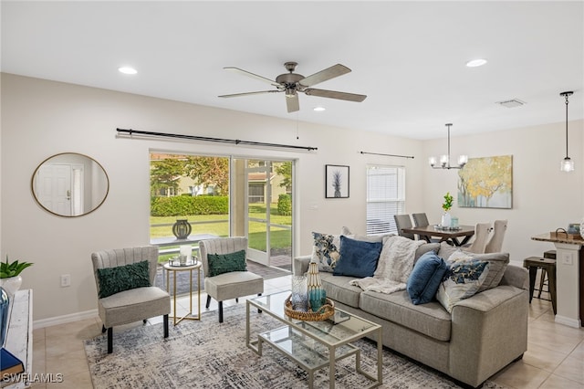 living room with light tile patterned flooring and ceiling fan with notable chandelier