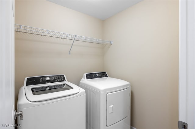 clothes washing area with washing machine and dryer