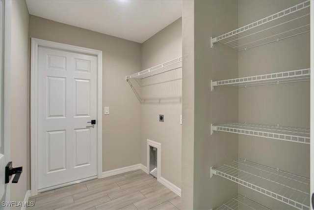 laundry room with light hardwood / wood-style flooring and electric dryer hookup