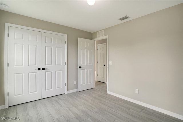 unfurnished bedroom featuring light hardwood / wood-style flooring and a closet